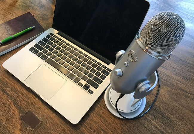 A podcast setup with microphone and laptop