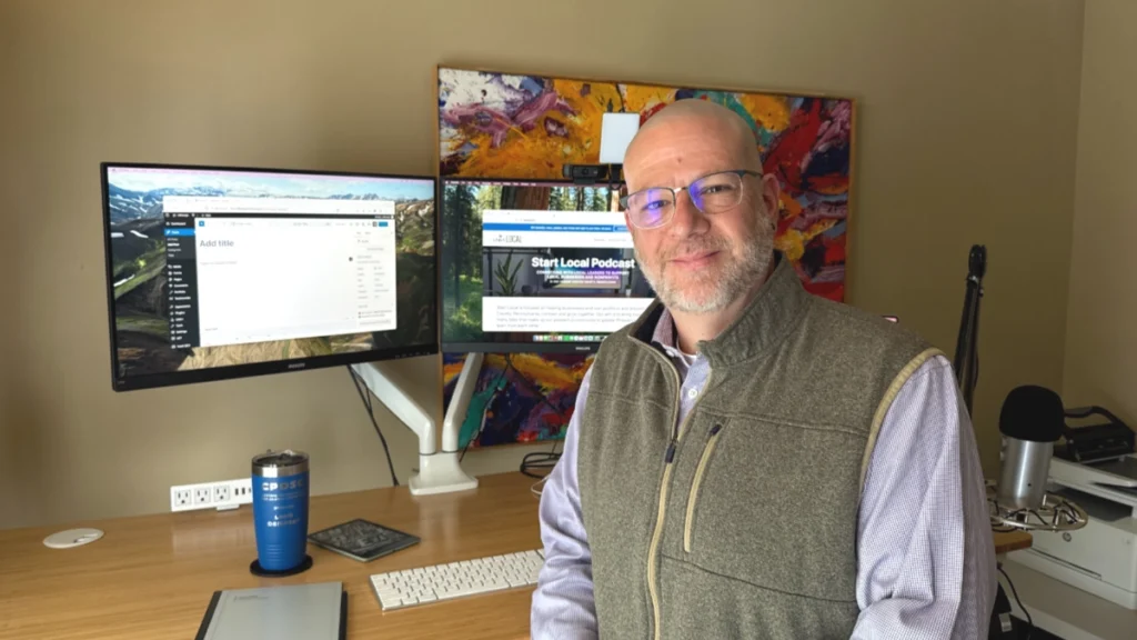 Liam Dempsey, standing in front of his desk, preparing to draft a blog post on a WordPress website.