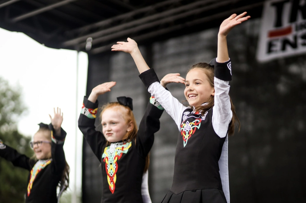 Girls from the Trinity Irish Dance Academy perform on stage.